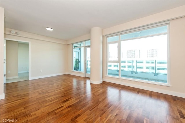 unfurnished room with wood finished floors and baseboards