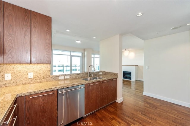 kitchen with a sink, dark wood-style floors, baseboards, dishwasher, and backsplash