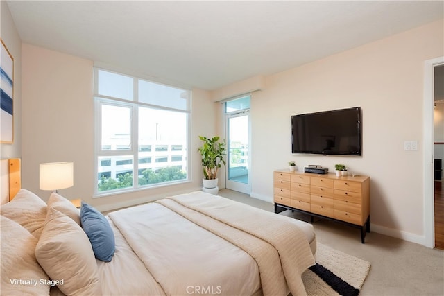 bedroom featuring light carpet and baseboards