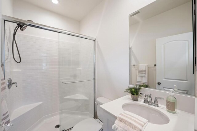 full bathroom featuring toilet, a stall shower, and vanity