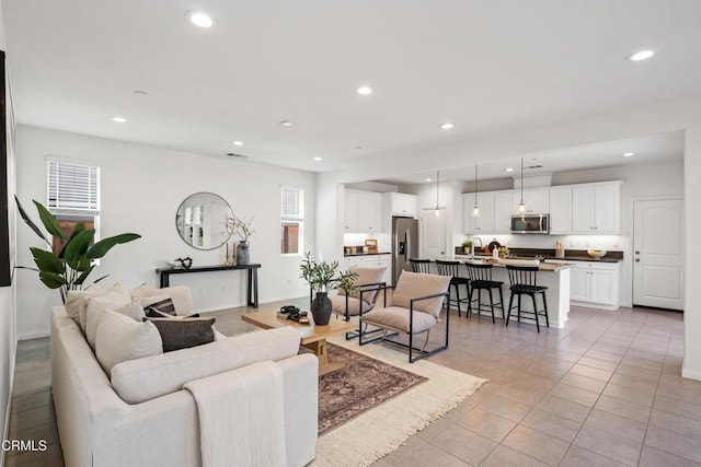 living area featuring light tile patterned floors, baseboards, and recessed lighting
