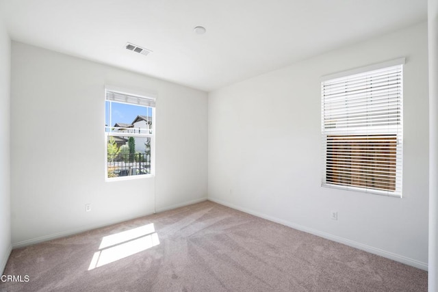 unfurnished room with baseboards, visible vents, and carpet floors