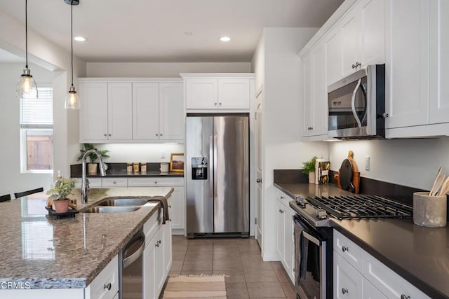 kitchen with recessed lighting, white cabinetry, decorative light fixtures, stainless steel appliances, and a sink