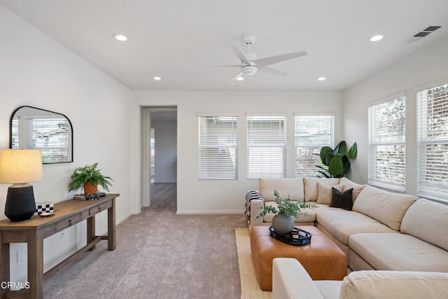 living area featuring light carpet, plenty of natural light, visible vents, and ceiling fan