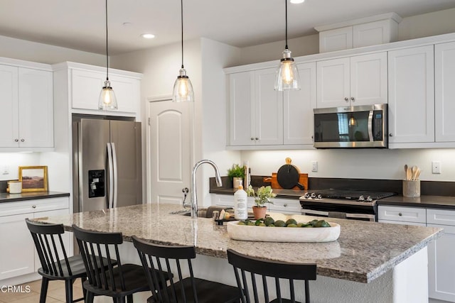kitchen featuring appliances with stainless steel finishes, a kitchen breakfast bar, white cabinetry, recessed lighting, and a center island with sink