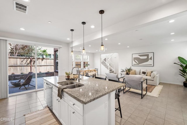kitchen featuring white cabinetry, light tile patterned flooring, visible vents, stainless steel dishwasher, and a sink