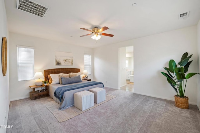 carpeted bedroom featuring ceiling fan, baseboards, visible vents, and connected bathroom
