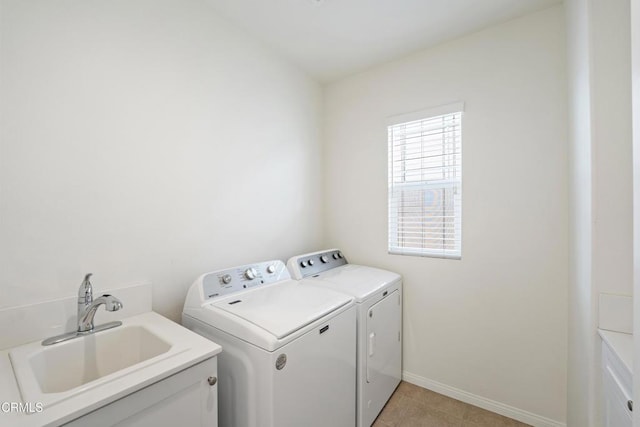 clothes washing area featuring baseboards, light tile patterned floors, washing machine and clothes dryer, laundry area, and a sink