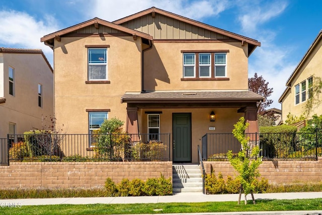 craftsman-style house with stucco siding, fence, and covered porch