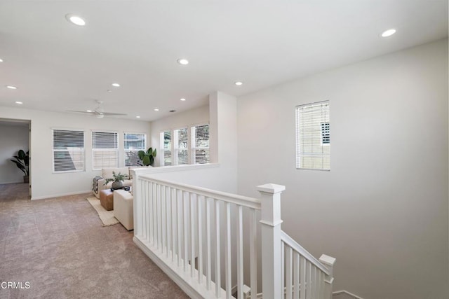 corridor with carpet floors, baseboards, an upstairs landing, and recessed lighting