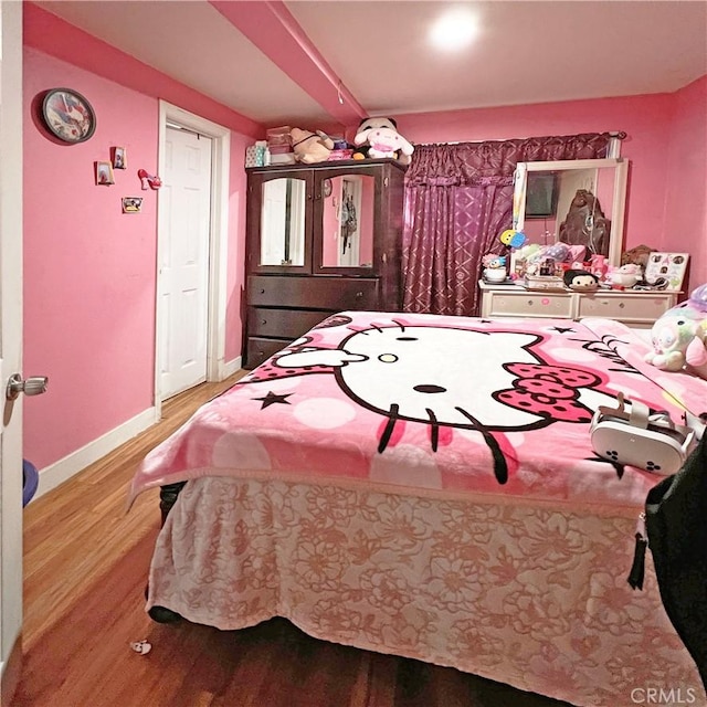 bedroom featuring baseboards and wood finished floors