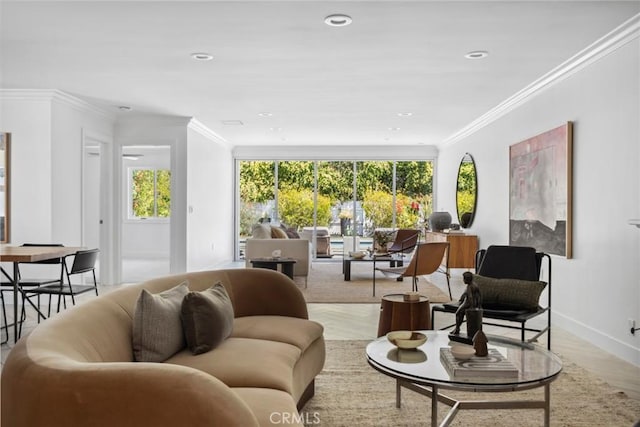 living area with ornamental molding, light wood finished floors, and baseboards