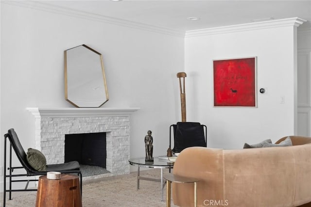 living area with a stone fireplace and crown molding