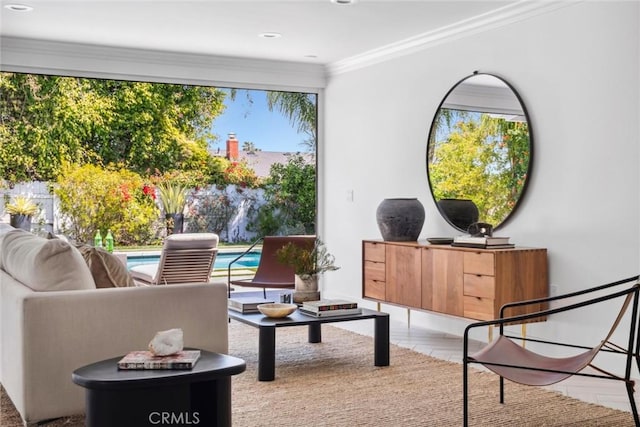 living area featuring a healthy amount of sunlight and crown molding
