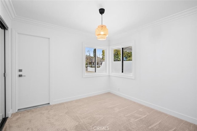 carpeted spare room featuring ornamental molding and baseboards