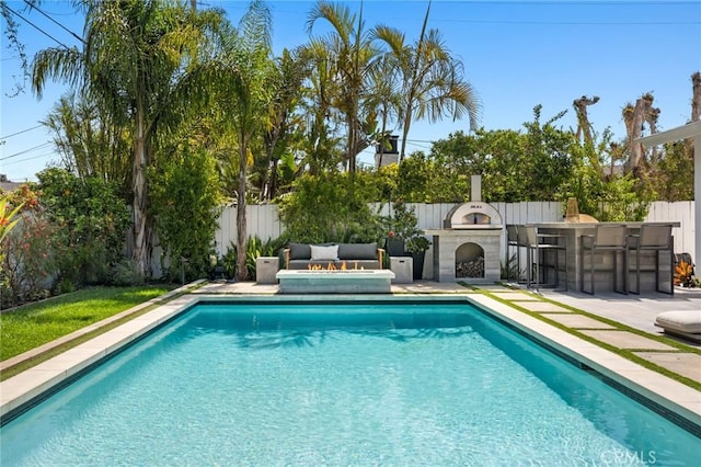 view of swimming pool featuring a fenced in pool, outdoor dry bar, a patio, and a fenced backyard