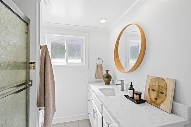 bathroom with baseboards, a shower with shower door, crown molding, and vanity