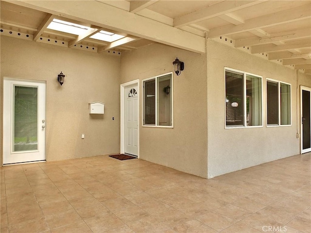 entrance to property featuring stucco siding and a patio