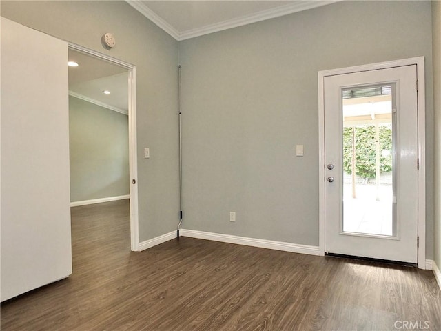 empty room with dark wood finished floors, crown molding, and baseboards