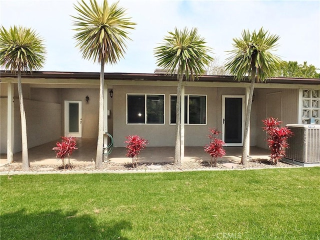 back of house with cooling unit, a yard, a patio, and stucco siding