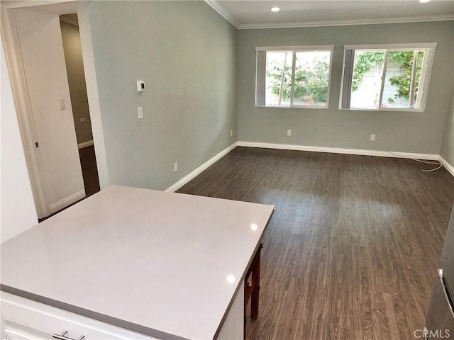 unfurnished room with dark wood-type flooring, crown molding, baseboards, and recessed lighting