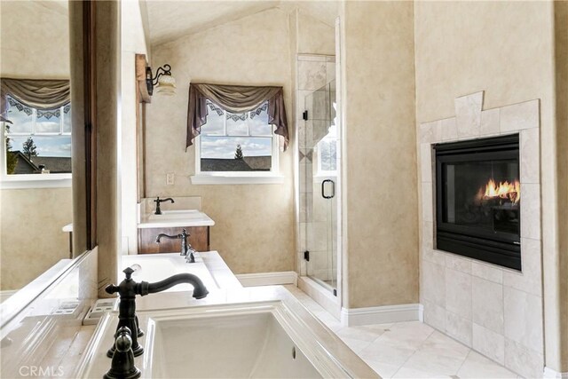 full bathroom featuring a shower stall, a tile fireplace, a bath, and vaulted ceiling