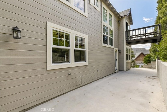 view of side of home with a patio and fence