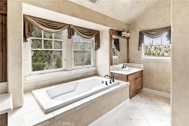 bathroom with vanity, baseboards, vaulted ceiling, tile patterned flooring, and a tub with jets