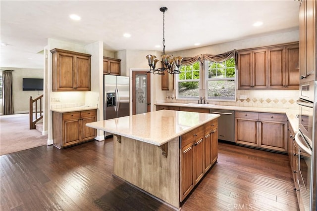 kitchen featuring a center island, brown cabinets, dark wood-style floors, and stainless steel appliances