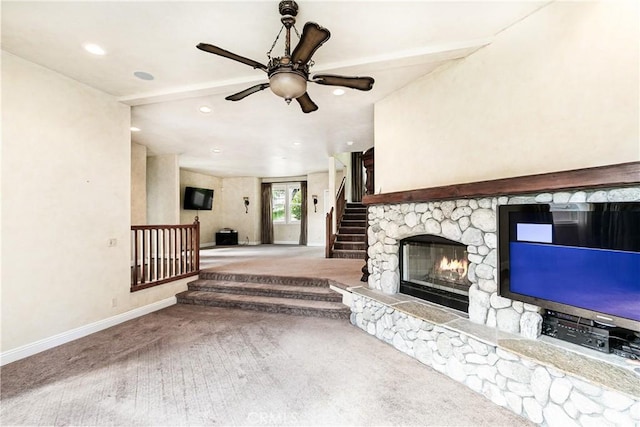 unfurnished living room featuring baseboards, a fireplace, carpet flooring, stairs, and ceiling fan