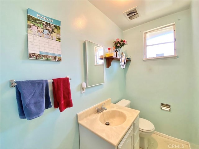 half bathroom with visible vents, baseboards, toilet, and vanity