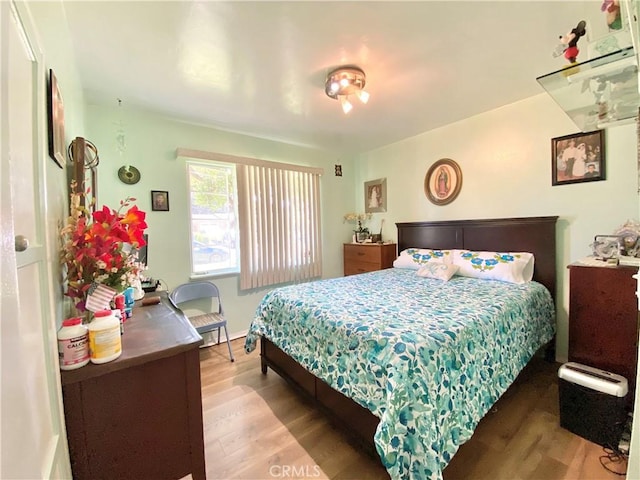 bedroom with baseboards and wood finished floors