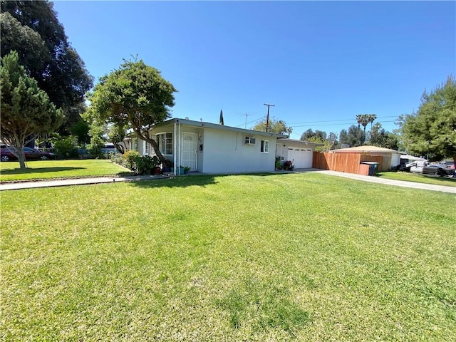 view of front of house featuring a garage, stucco siding, a front yard, and concrete driveway