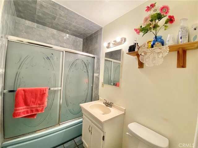 full bath with vanity, tile patterned flooring, combined bath / shower with glass door, and toilet