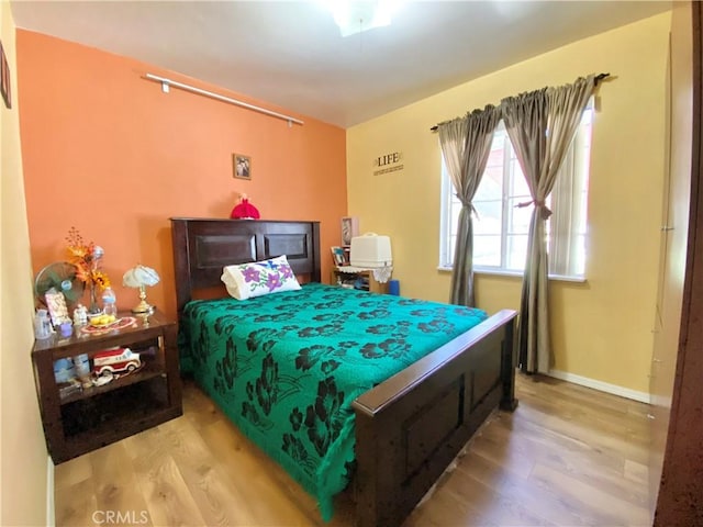 bedroom with baseboards and wood finished floors