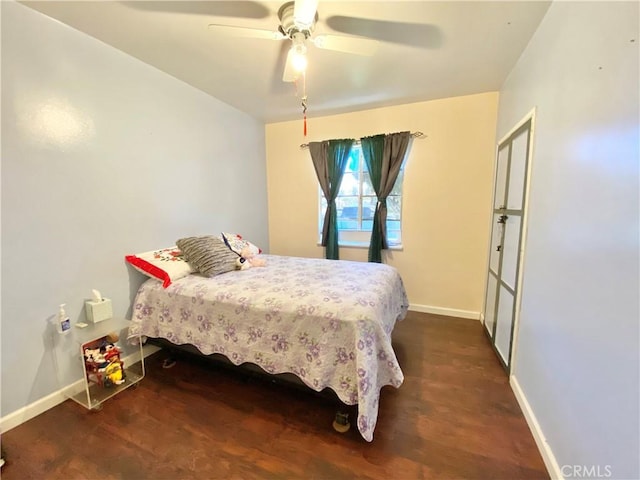 bedroom with baseboards, a ceiling fan, and dark wood finished floors