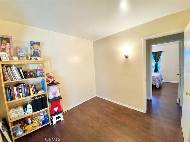interior space with baseboards and wood finished floors