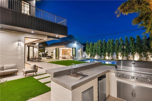 view of patio / terrace featuring a sink, an outdoor pool, area for grilling, and an outdoor kitchen