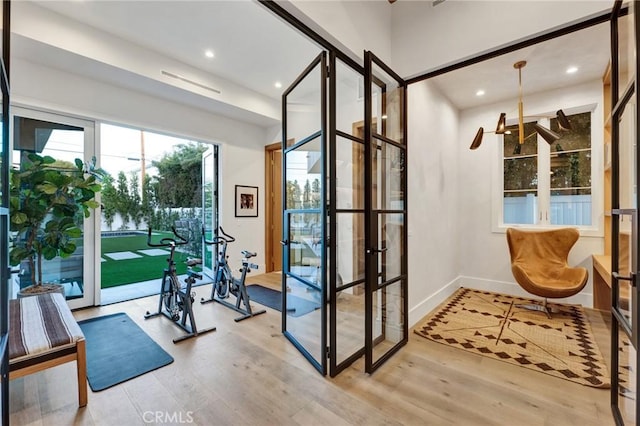 interior space featuring recessed lighting, french doors, baseboards, and wood finished floors