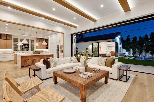 living room featuring light wood finished floors, beamed ceiling, and recessed lighting
