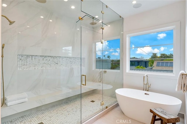 full bathroom featuring a soaking tub, a marble finish shower, and recessed lighting