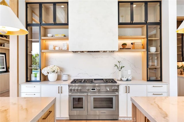 kitchen featuring glass insert cabinets, range with two ovens, open shelves, and white cabinetry