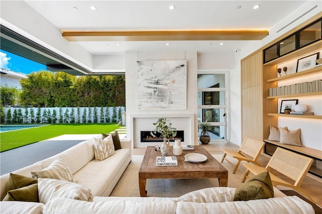 living room with wood finished floors, a fireplace, beam ceiling, and recessed lighting