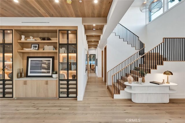 foyer featuring stairs, light wood-style flooring, and wooden ceiling