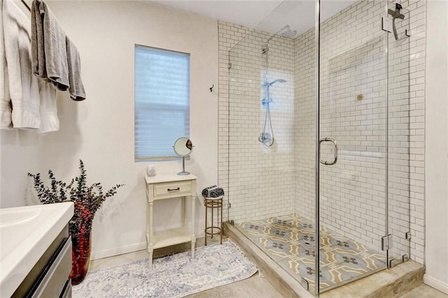 bathroom featuring baseboards, a shower stall, and vanity