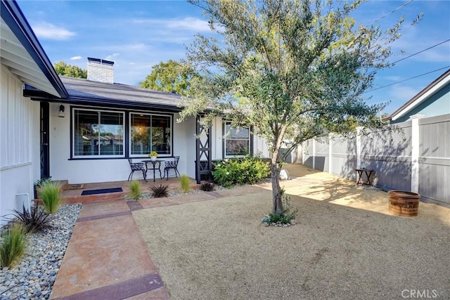 view of yard featuring covered porch and fence