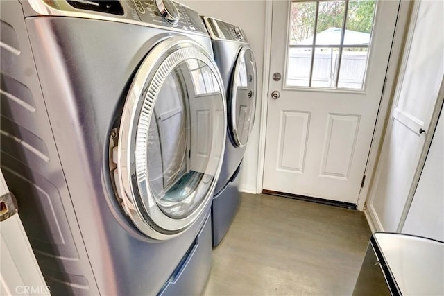 clothes washing area with wood finished floors, washer and clothes dryer, and laundry area