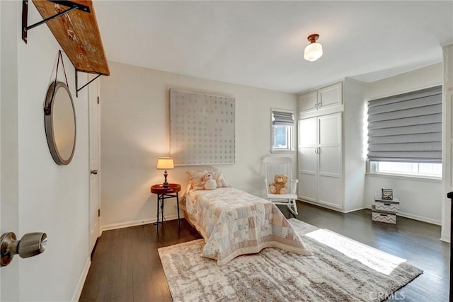 bedroom with baseboards and dark wood-type flooring