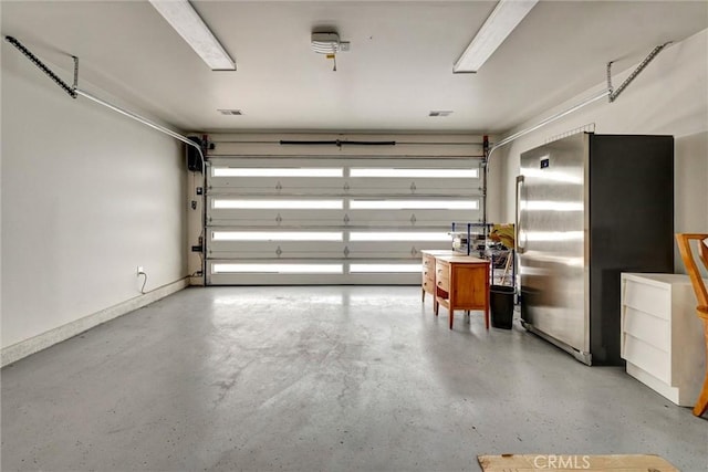 garage featuring freestanding refrigerator and baseboards