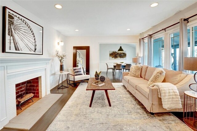 living area featuring recessed lighting, wood finished floors, and a fireplace